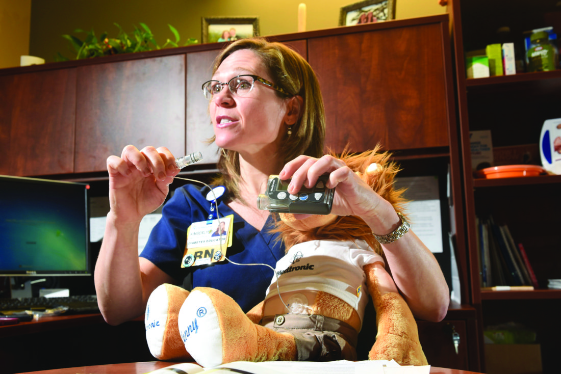 In this Wednesday, Jan. 11, 2017 photo, diabetes educator Kimberly P. Miller, BSN, RN, CDE, holds a Medtronic Minimed diabetes insulin pump in her office at CHI Memorial, in Chattanooga, Tenn. (Tim Barber/Chattanooga Times Free Press via AP)