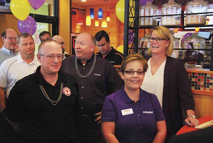 Curt Oxyer, center, director of operations for Popeyes Louisiana Chicken franchisee GPS Hospitality, speaks Monday at the grand opening of the Popeyes on Grand Central Avenue in Vienna, the chain's first location in West Virginia. Also pictured are, clockwise from front left, GPS district leader Sean Dawe. GPS Vice President of Operations Mike Kovac, GPS director of marketing Chris Jasinski and Vienna Popeyes general manager J.J. Jaso. (Photo by Evan Bevins)
