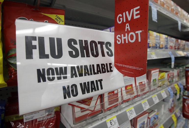 FILE - In this Sept. 16, 2014 file photo, a sign telling customers that they can get a flu shot in a Walgreen store is seen in Indianapolis. Kids may get more of a sting from flu vaccination this fall: Doctors are gearing up to give shots only, because U.S. health officials say the easy-to-use nasal spray version of the vaccine isn't working as well as a jab. Needle-phobic adults still have some less painful options. But FluMist, with its squirt into each nostril, was the only ouch-free alternative for children, and has accounted for about a third of pediatric flu vaccinations in recent years. (AP Photo/Darron Cummings, File)