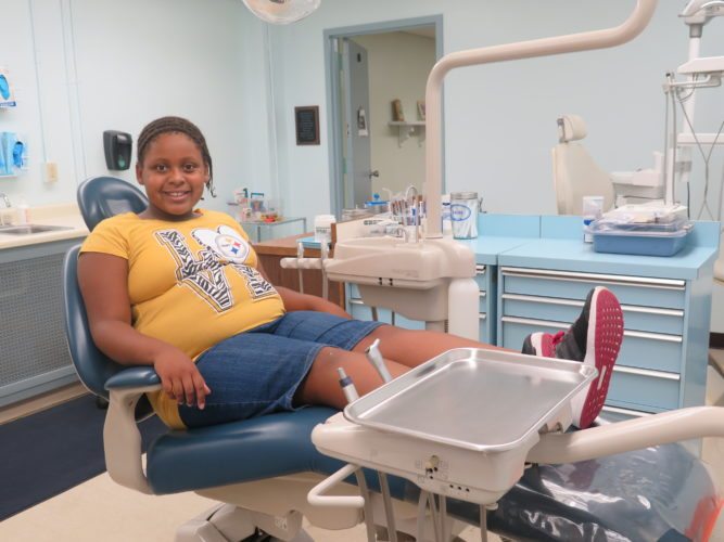 Zahraia Lewis, a third-grade student at Madison School, sits back for an examination at the dental clinic located within the school.