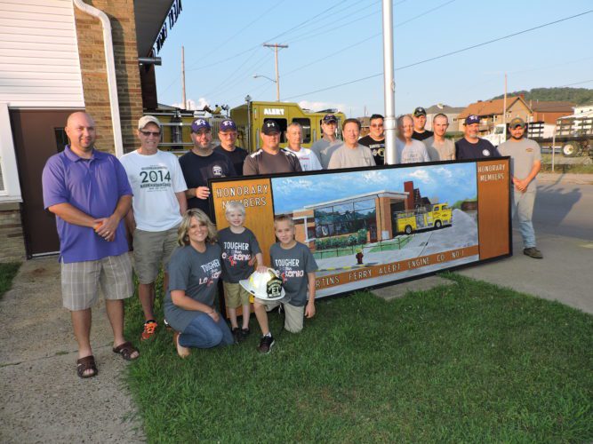 MEMBERS OF the Alert Engine Co. in Martins Ferry, along with the Zambori family, stand with a newly repainted work of art depicting the station's yellow fire truck by retired art teacher Joe Ellis, who originally created the painting when he was a senior in high school. Standing from left are Chad Zambori, artist Joe Ellis, Capt. Ron Hilton, Terry Greer, Todd Roberts, Don Dunfee, Jeremy Rife, John Ayers, George Miller, Bobby Bennett, Dylan Freeman, Dave Maguire and Bill West. Kneeling in front are Natalie Zambori and her sons Leo and Nolan Zambori.