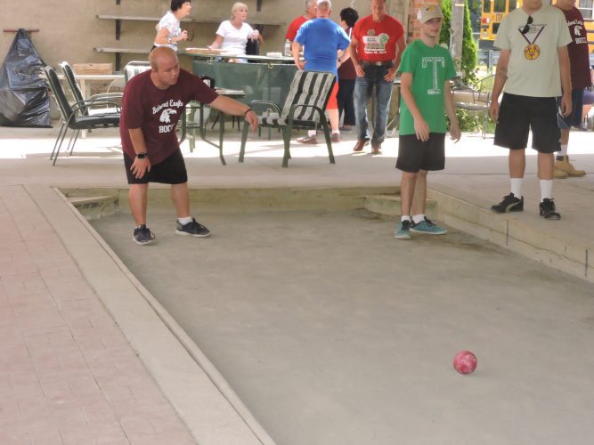 T-L Photo/ ROBERT A. DEFRANK Belmont County competitor Stevie Rawlins takes a throw during a bocce tournament at the Sons of Italy Bellaire headquarters Saturday. Tuscarawas County competitor Carter McConnell, right, prepares to go next.
