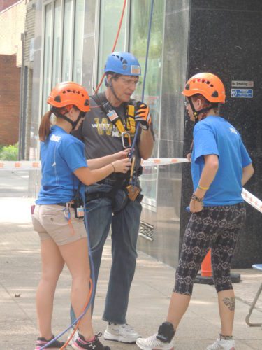 EVENT -- Steve Greiner, president of West Liberty University, finishes his journey down the walls of the Stone Center for the YWCA Over the Edge event Saturday. -- Drew Parker