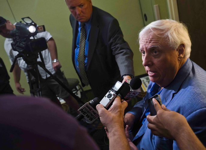 FILE - In this Tuesday Aug. 30, 2016, file photo, West Virginia Democratic gubernatorial candidate Jim Justice, right, speaks with members of the media after a roundtable discussion with representatives from various social work and mental health agencies, in Charleston, W.Va. On Friday, Sept. 30, 2016, federal officials announced that they've reached a settlement requiring $5 million in upgrades to prevent further pollution by Appalachian coal mines owned by Justice. The Environmental Protection Agency and Department of Justice announced the settlement with Southern Coal Corporation and 26 affiliates on Friday. (Christian Tyler Randolph/Charleston Gazette-Mail via AP, File)